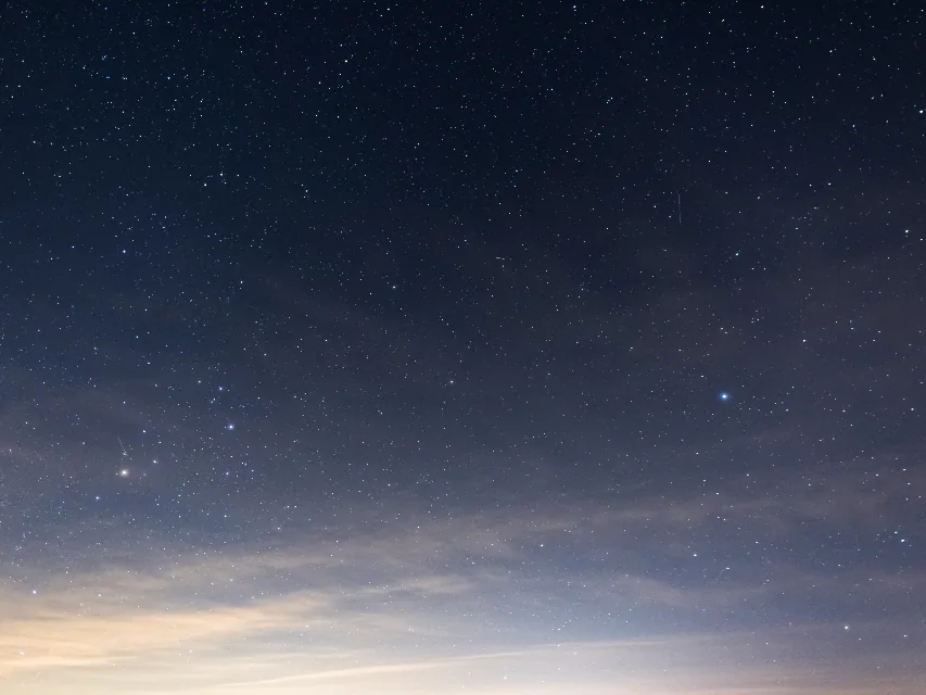 Ciel étoilé au-dessus d'un horizon encore clair